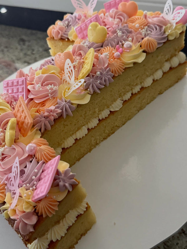 1st birthday pastel pink orange yellow and lilac layered number cake